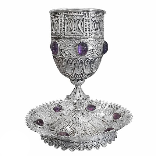 Silver goblet with purple gemstones on white background