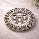 Silver plate with intricate designs on a light background